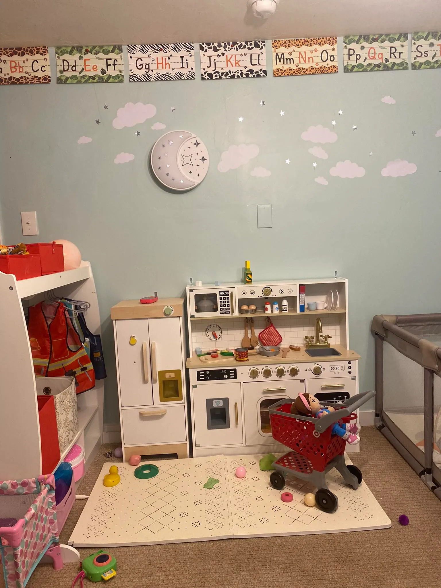 Dramatic play area with toy kitchen and learning materials